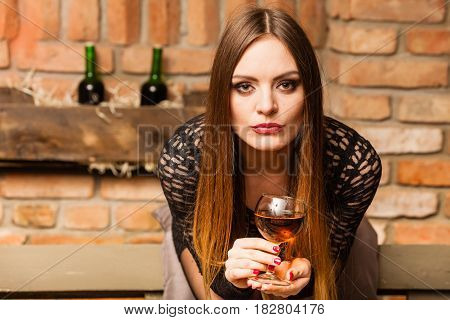 Woman Tasting Wine In Rural Cottage Interior