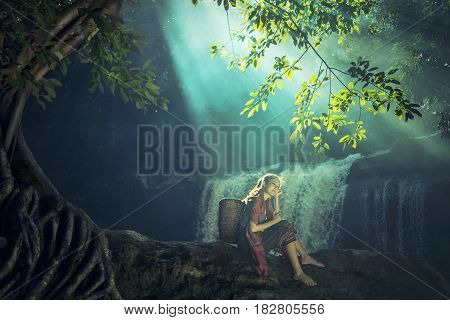 Asian woman sitting alone at the waterfall Thailand