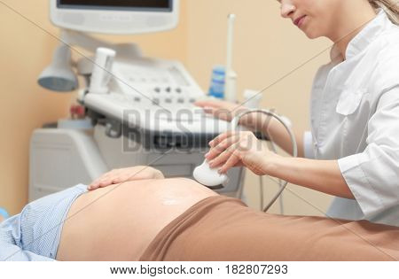 Pregnant woman undergoing ultrasound scan in modern clinic