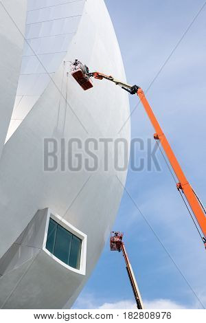 Marina Bay Sand Singapore - May 9 2015 : Worker is painting the outside of ArtScience Museum Singapore by standing in basket of articulating boom lift.