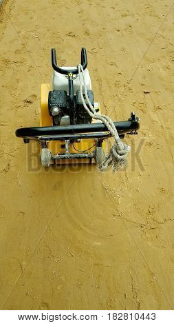 Vibratory plate compactor under construction and background