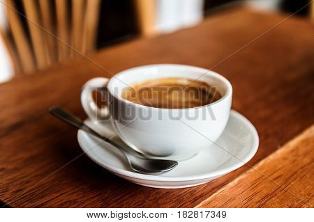 Coffee cup in white cup and wooden table