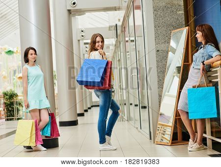 Happy woman with shopping bags posing in front of miror