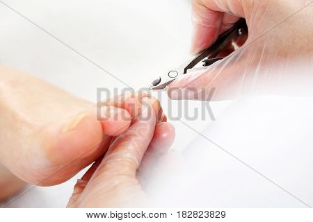 Podology, cutting skins.
Professional pedicure in the beauty salon.
Nail clipping at the feet, woman on pedicure.
The beautician cuts the skin with fingernails and performs professional pedicure.