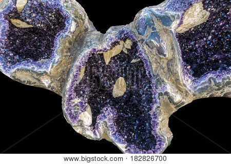 Amethyst geode on black background. Beautiful natural crystals gemstone. Close up macro shot.