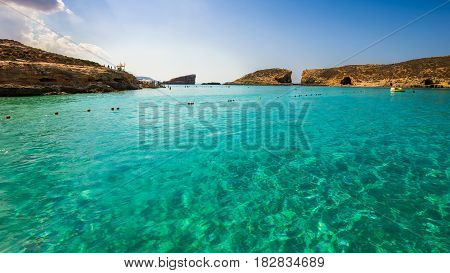 Comino Malta - The beautiful azure sea water at the Blue Lagoon on the island of Comino on a bright sunny summer day