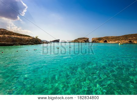 Comino Malta - The beautiful azure sea water at the Blue Lagoon on the island of Comino on a bright sunny summer day