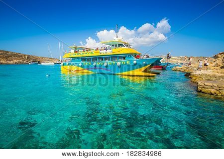 BLUE LAGOON COMINO MALTA - OCTOBER 17 2016: Visitors and tourists arriving on a boat to enjoy the clear turquoise water and the other wonders of the Blue Lagoon on the island of Comino Malta.