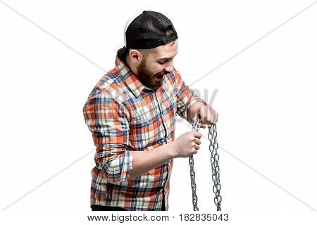 Redhead Bearded man wearing a baseball cap and shirt making streght against a chain. Isolated on white.