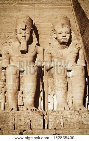 The Abu Simbel temple. View of the statues represent Ramesses II and his wife Nefertari. Edited as a vintage photo with dark edges.