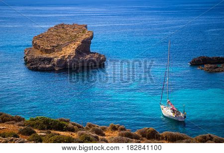 Blue Lagoon Malta - Sailing boat at the famous Blue Lagoon at the Island of Comino on bright sunny summer day with crystal clear azure sea water