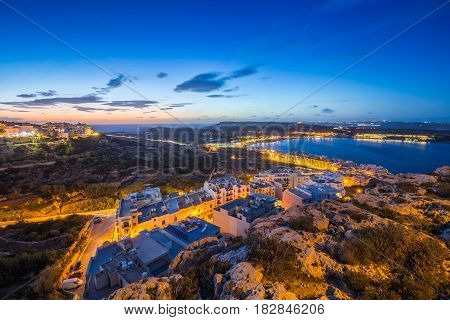 Il-Mellieha Malta - Beautiful panoramic skyline view of Mellieha bay after sunset with blue sky and clouds