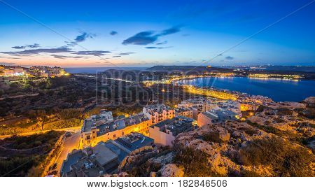 Il-Mellieha Malta - Beautiful panoramic skyline view of Mellieha bay after sunset with blue sky and clouds