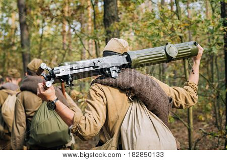 Reenactors Men Dressed As Russian Soviet Red Army Infantry Soldiers Of World War II Marching In Forest With Weapon Machine-gun At Historical Reenactment