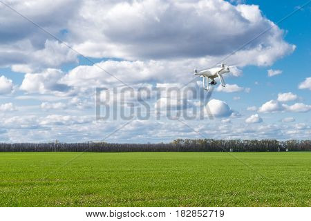 flying drone quadrocopter at the green field.