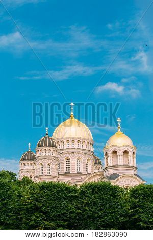 Riga Nativity Of Christ Cathedral - Famous Church And Landmark. Golden Yellow Domes On Blue Sunny Sky Background At Summer Season