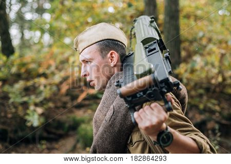 Dyatlovichi, Belarus - October 1, 2016: Young Reenactor Man Dressed As Russian Soviet Red Army Infantry Soldier Of World War II Marching In Forest With Weapon Machine-gun At Historical Reenactment