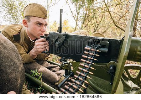 Dyatlovichi, Belarus - October 1, 2016: Reenactors Dressed As Russian Soviet Red Army Soldiers Of World War II Hidden Sitting With Maxim's Machine Gun Weapon In An Ambush In Autumn Forest