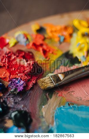 color palette with fresh paint and brush on wood table