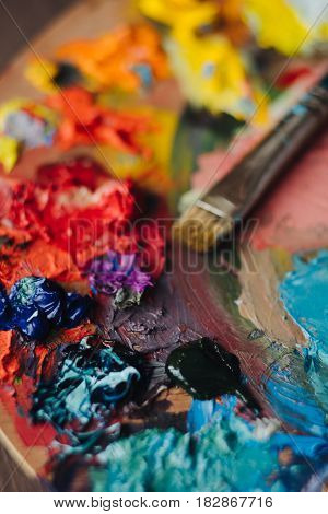 color palette with fresh paint and brush on wood table