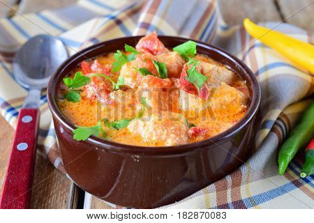 Traditional Hungarian dish witth paprika and chicken in a creamy sause In a ceramic pot. Healthy eating concept