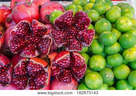 close up colorful red pomegranate and green lemon fresh juice from tropical