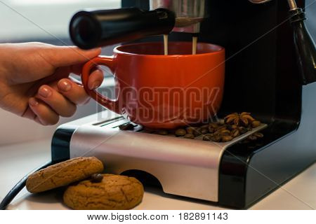 Girl make fresh coffee in a coffee machine with flavoring