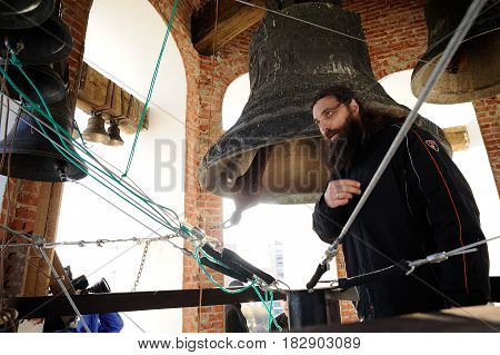Orel Russia - April 20 2017: Orthodox bell-ringing festival. Bell ringer monk crossing himself after ringing church bells horizontal