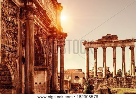 Arch of Emperor Septimius Severus and Temple of Saturn in the distance at the Roman Forum. Rome, Italy.