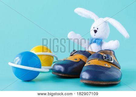 Classic Rattle Toy With Booties On Aquamarine Background