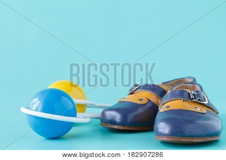 Classic Rattle Toy With Booties On Aquamarine Background