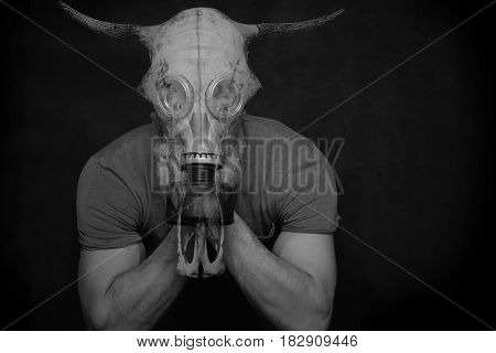 A mystical, fantastic photo - a double exposition - a man in a gas mask and a bull's skull