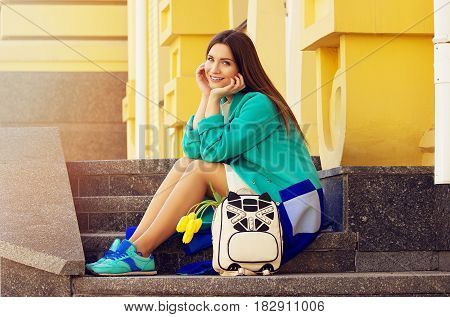 Cute Fashionable Girl. Young And Beautiful Girl In Blue Coat And Blue Sneakers Sitting On The Stairs