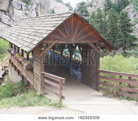 Covered bridge with pansies leading to mountain range