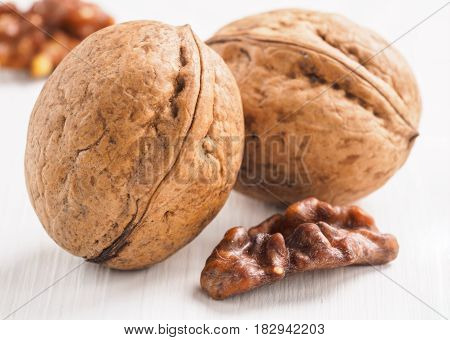 Close up view on inshell walnut on white wooden background