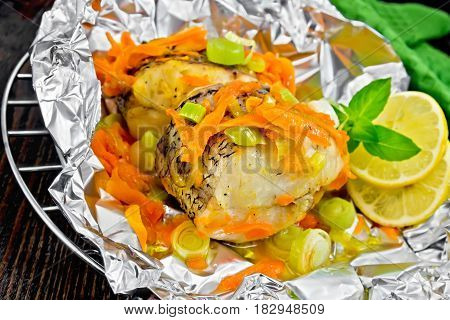 Pike With Carrots And Basil In Foil On Dark Board