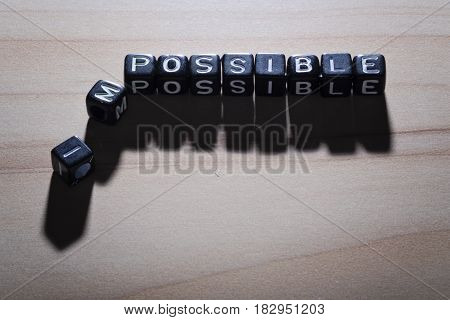 POSSIBLE and IMPOSSIBLE, by black alphabet beads