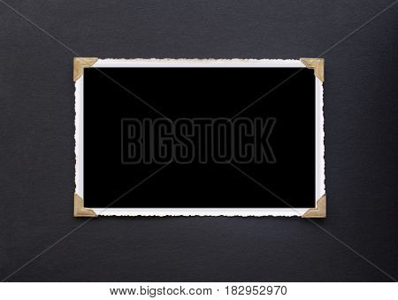 Photo frame - real old photo with black blank space for copy photo or text pasted with gold coloured photo holder corners onto black vintage album paper page