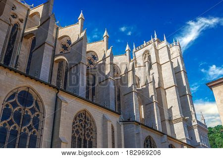 Side bottom view of Part of cathedral Saint Jean-Baptiste in Lyon, France. Summer day with clear blue sky and white clouds.