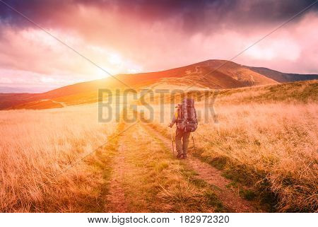 Hiker with bagpack walking the treck to the top of mountain