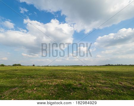 green meadow in springtime and blue sky with big clouds Wisseler Dünen Kalkar Germany