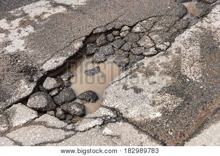 Large unfixed pothole on Montreal street in springtime