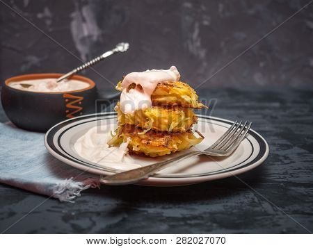 Cabbage Oladi Are Lying On A Plate On A Plate, Poured With Sour Cream, A Cup Of Stewed Sour Cream On