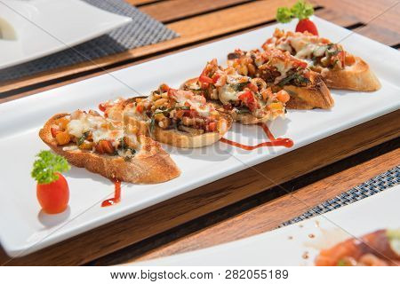 Dish With Bruscetta, Baked Vegetables And Cheese