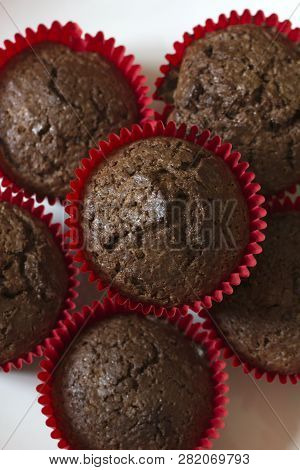 Just Baked Chocolate Muffins. Chocolate Cupcakes. Just Baked Chocolate Cupcakes On A White Wooden Ta