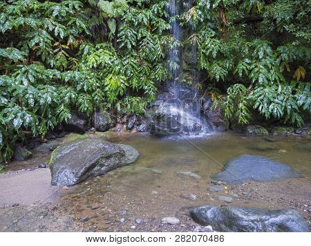 Waterfall Cascade Falling On Stone And Lush Vegetation On Hiking Trail Janela Do Inferno, In Fainfor