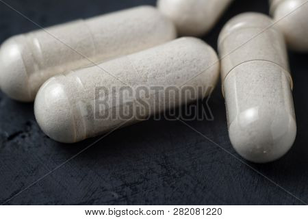 White Medical Capsules Of Glucosamine Chondroitin, Healthy Supplement Pills On A Dark Background, Ma