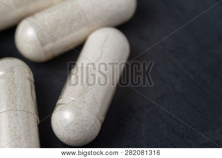 White Medical Capsules Of Glucosamine Chondroitin, Healthy Supplement Pills On A Dark Background, Ma