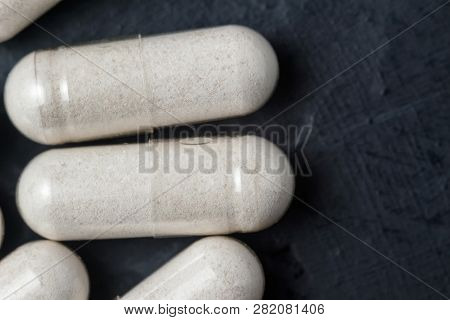 White Medical Capsules Of Glucosamine Chondroitin, Healthy Supplement Pills On A Dark Background, Ma