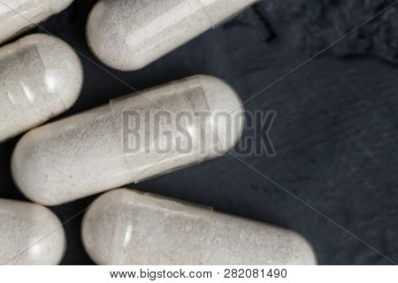 White Medical Capsules Of Glucosamine Chondroitin, Healthy Supplement Pills On A Dark Background, Ma